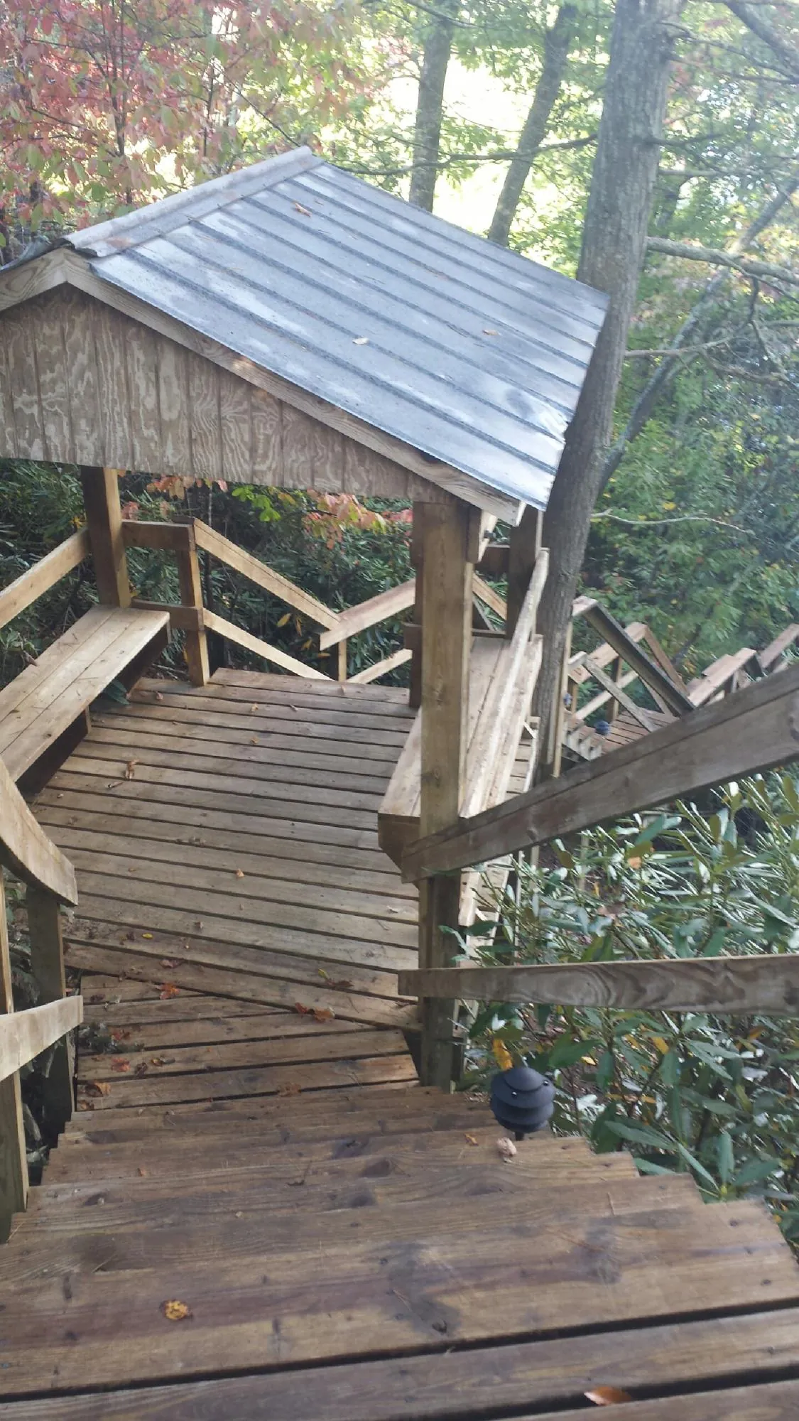 Metal roofed shelter over wooden steps on a wooded walkway — Skylight Repair & Installation work by our crew in Mountville